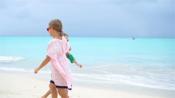 Twee kleine gelukkige meisjes hebben veel plezier op tropische strand spelen samen — Stockvideo