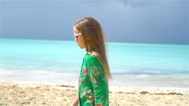 Hermosa niña en vestido en la playa divirtiéndose . — Vídeo de stock