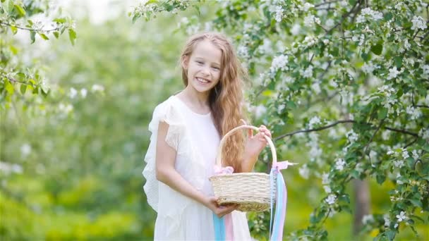 Liebenswertes kleines Mädchen im blühenden Apfelgarten an einem schönen Frühlingstag — Stockvideo