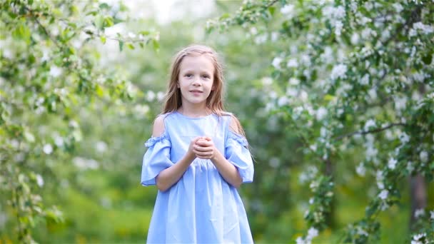 Söt liten flicka i blommande äppelträdgård på vacker vårdag — Stockvideo