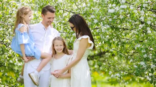 Familj på fyra i blommande trädgård på vacker vårdag — Stockvideo