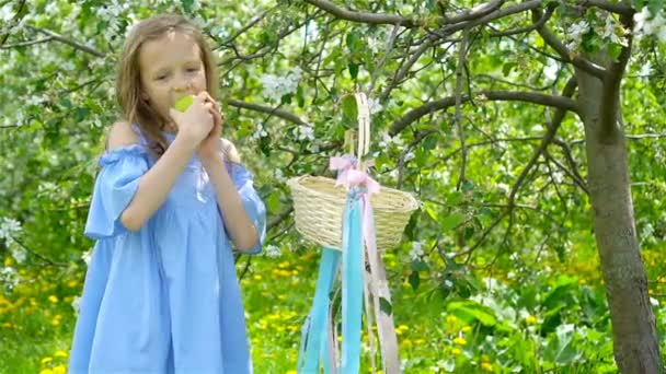 Αξιολάτρευτο κοριτσάκι στον ανθισμένο κήπο με μήλα την όμορφη ανοιξιάτικη μέρα — Αρχείο Βίντεο