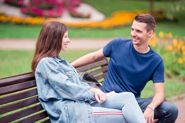 Relaxed young family on the bench in the park