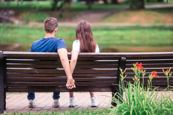 Relaxed young family on the bench in the park — Stock Photo, Image