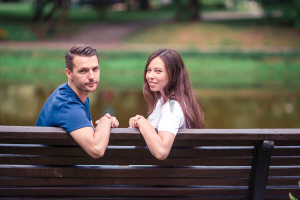 Relaxed young family on the bench in the park