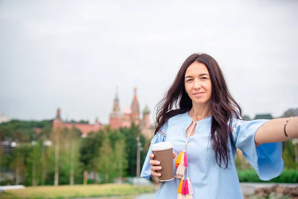 Szczęśliwa młoda miejska kobieta pijąca kawę w europejskim mieście. — Zdjęcie stockowe
