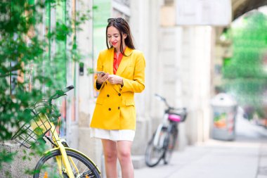 Kadın konuşmak yanında onun smartphone City. İtalyan şehri açık havada genç çekici turist