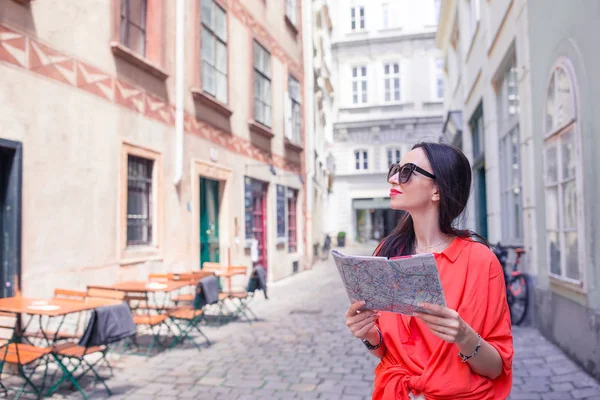 Mujer joven con un mapa de la ciudad. Viajar chica turística con mapa en Viena al aire libre durante las vacaciones en Europa . — Foto de Stock