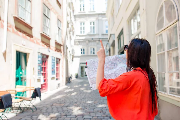 Mujer joven con un mapa de la ciudad. Viajar chica turística con mapa en Viena al aire libre durante las vacaciones en Europa . — Foto de Stock