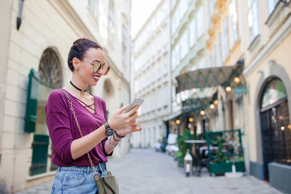 Vrouw praat door haar smartphone in de stad. Jonge aantrekkelijke toeristische buitenshuis in Italiaanse stad — Stockfoto