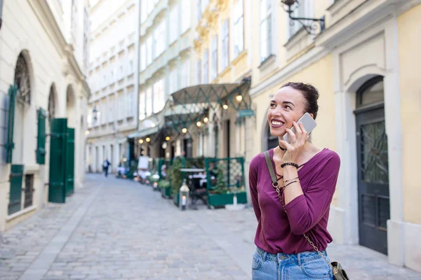 Mujer hablar con su teléfono inteligente en la ciudad. Joven turista atractivo al aire libre en la ciudad italiana — Foto de Stock