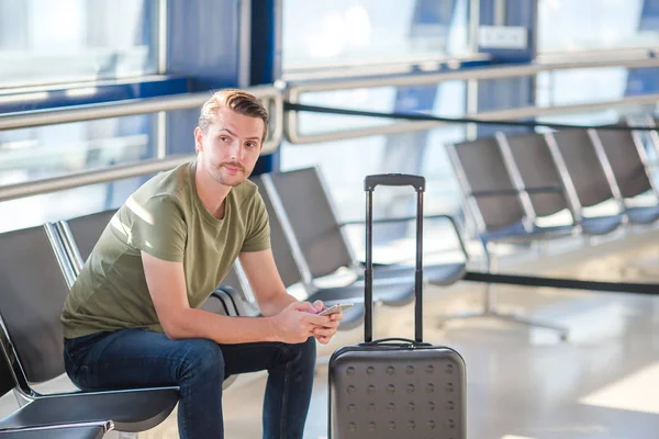Επιβάτης σε σαλόνι αεροδρομίου που περιμένει αεροσκάφος. Νεαρός με κινητό στο αεροδρόμιο περιμένει να προσγειωθεί — Φωτογραφία Αρχείου