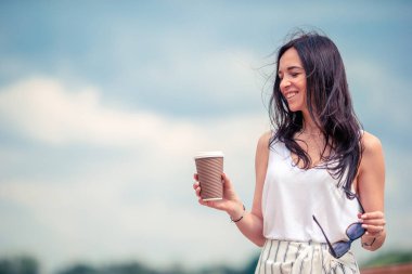 Avrupa 'da kahve içen mutlu genç şehir kadını. Avrupa 'da tatillerde sıcak içeceklerle gezen bir turist kadın..