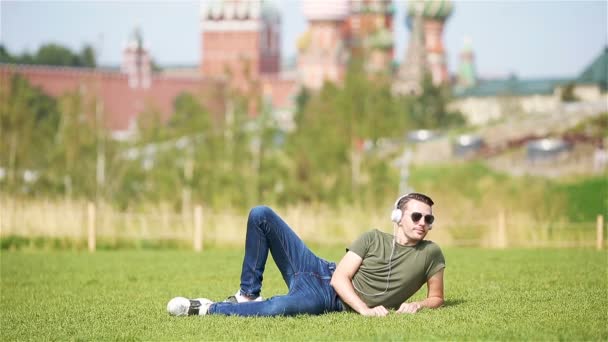 Vrolijke jonge stedelijke man geniet van zijn vakantie in de stad — Stockvideo