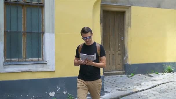 Adam turistik bir şehir haritası ve Avrupa sokakta sırt çantası ile. Beyaz çocuk Avrupa Haritası ile seyir. — Stok video