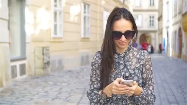 Kvinnan promenader i staden. Ung attraktiv turist utomhus i europeisk stad — Stockvideo
