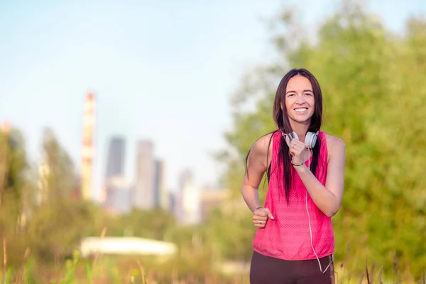 Giovane donna sorridente che fa esercizi sportivi all'aperto — Foto Stock