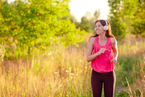 Joven mujer sonriente haciendo ejercicios deportivos al aire libre — Foto de Stock