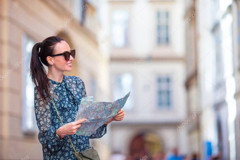 Young woman with a city map in city. Travel tourist girl with map in Vienna outdoors during holidays in Europe.