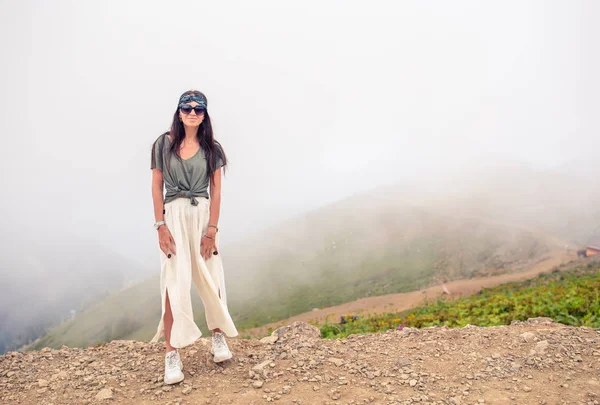 Hermosa joven feliz en las montañas en el fondo de la niebla —  Fotos de Stock
