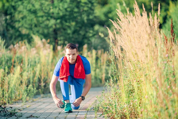 Спортивный молодой человек делает спортивные упражнения на открытом воздухе в парке — стоковое фото