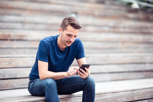 Man is het lezen van SMS-bericht op mobiele telefoon tijdens het wandelen in het park — Stockfoto