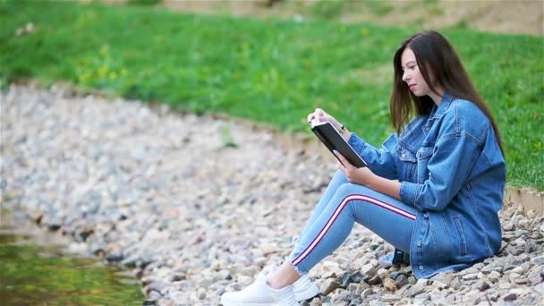 Ontspannen jonge vrouw lezing boek — Stockvideo