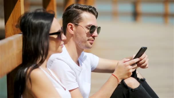 公園内のスマートフォンを使った楽しいカップルの写真 — ストック動画
