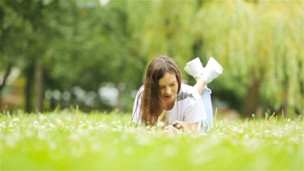 Расслабленная молодая женщина читает книгу — стоковое видео
