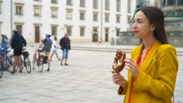 Hermosa Mujer Joven Sosteniendo Pretzel Caminando Por Vieja Calle Viena — Vídeos de Stock