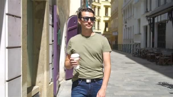 Happy young urban man drinking coffee in european city outdoors — Stock Video