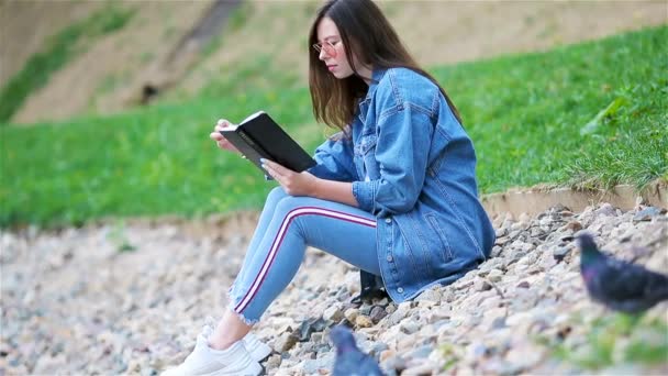 Entspannte junge Frau liest Buch — Stockvideo