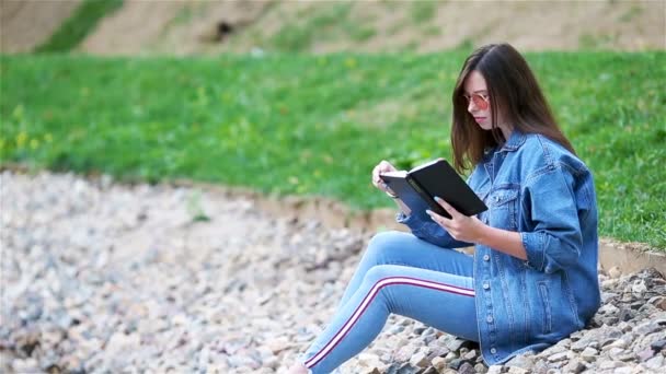 Avslappnad ung kvinna läsa bok — Stockvideo