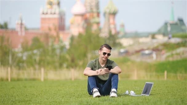 Man werkt door laptop terwijl u ontspant in het park — Stockvideo