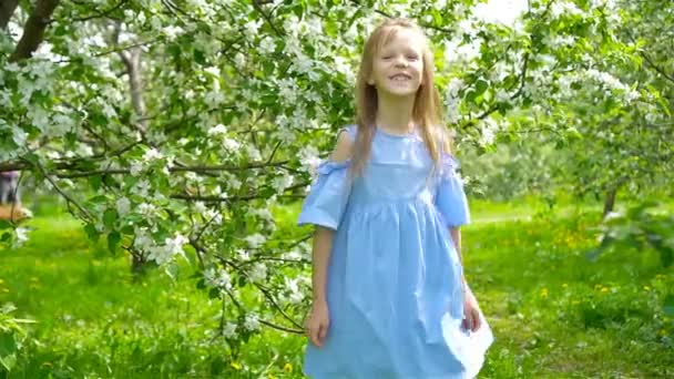 Söt liten flicka i blommande äppelträdgård på vacker vårdag — Stockvideo