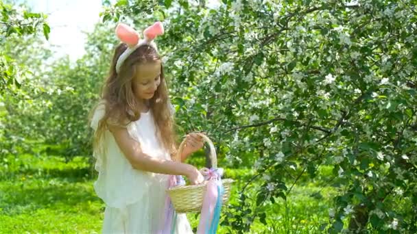 Schattig klein meisje in bloeiende appeltuin op mooie lentedag — Stockvideo