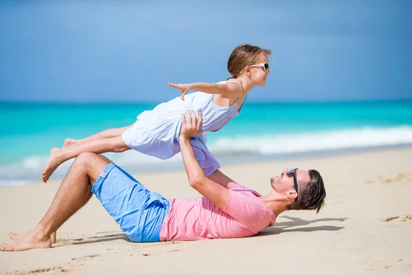 Семья отца и спортивная маленькая девочка веселятся на пляже — стоковое фото