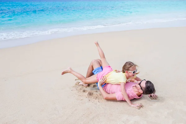 父亲和运动的小女孩的家庭在海滩上玩得开心 — 图库照片