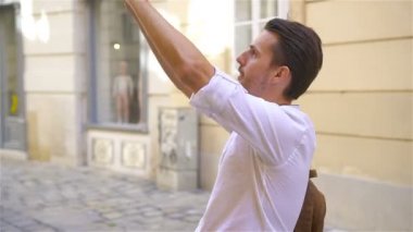 Genç adam eski Avrupa şehrinin özçekimini yapıyor.