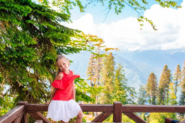 Beautiful happy little girl in mountains in the background of fog — Stock Photo, Image