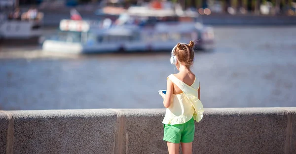 Little adorable girl listening music in the park — Stock Photo, Image