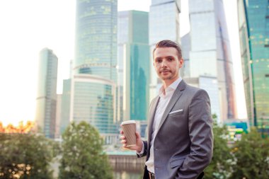 İşadamı cam gökdelenin karşısında dikilirken fotokopi alanına bakıyor
