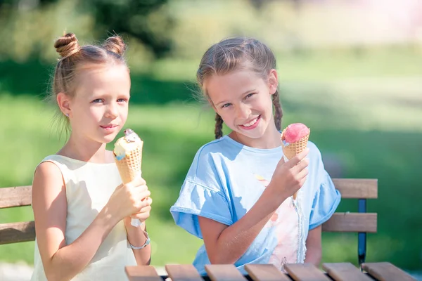 Petites filles manger de la glace en plein air à l'été dans un café en plein air — Photo