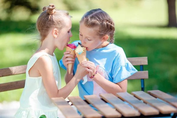 Little girls eating ice-cream outdoors at summer in outdoor cafe — Stock Photo, Image