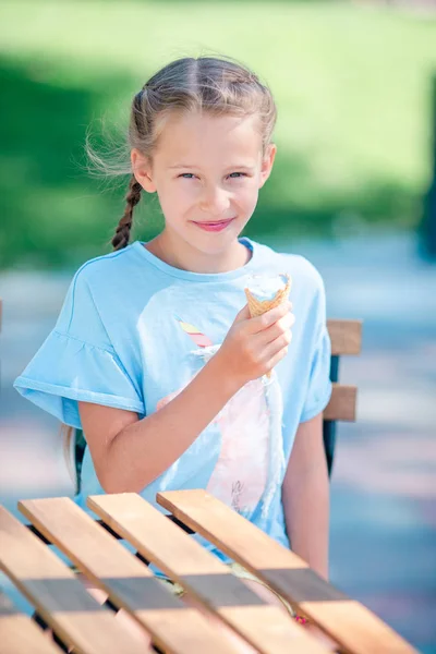 Küçük kız dondurma açık havada yaz aylarında açık kafe yeme. — Stok fotoğraf