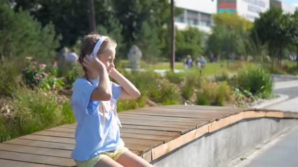 Little adorable girl listening music in the park — Stock Video