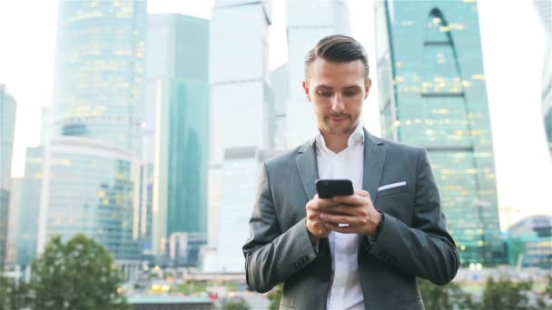 Joven hombre caucásico sosteniendo smartphone para el trabajo de negocios . — Vídeo de stock