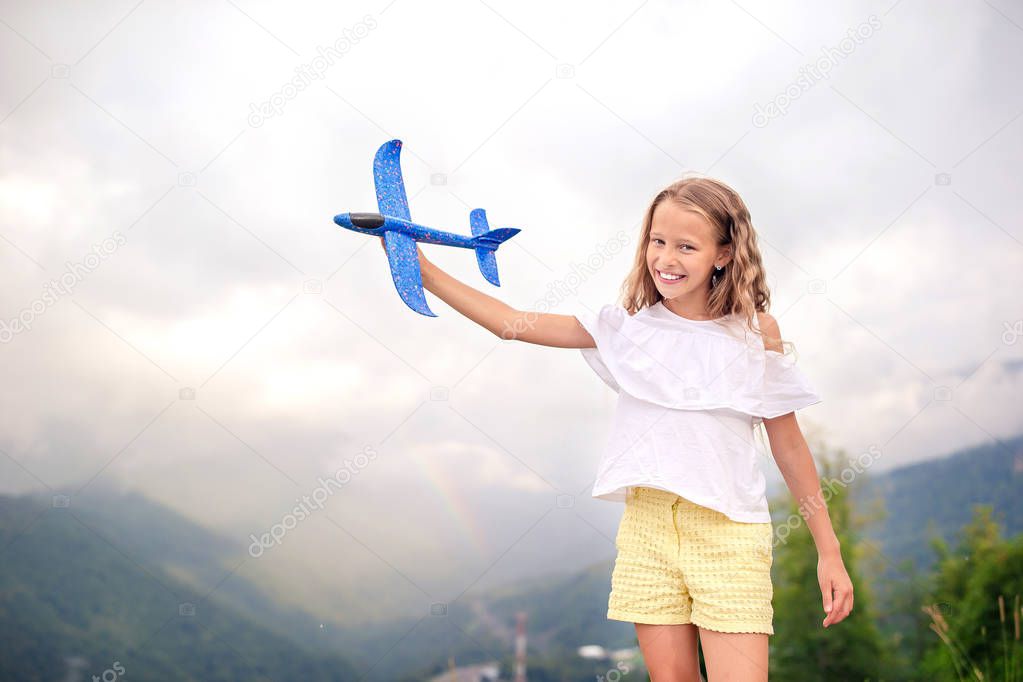 Adorable happy little girl in mountains in the background of beautful landscape. Happy kid with