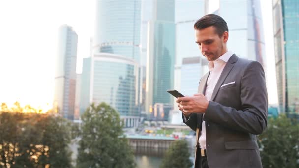 Joven hombre caucásico sosteniendo smartphone para el trabajo de negocios . — Vídeos de Stock