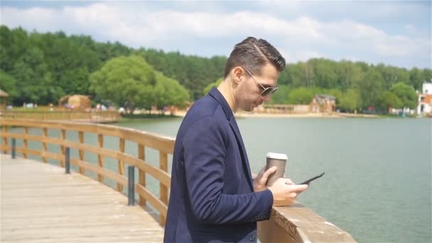 Jovem homem urbano feliz bebendo café na cidade europeia ao ar livre — Vídeo de Stock